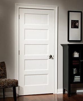 A white door in the corner of a room.